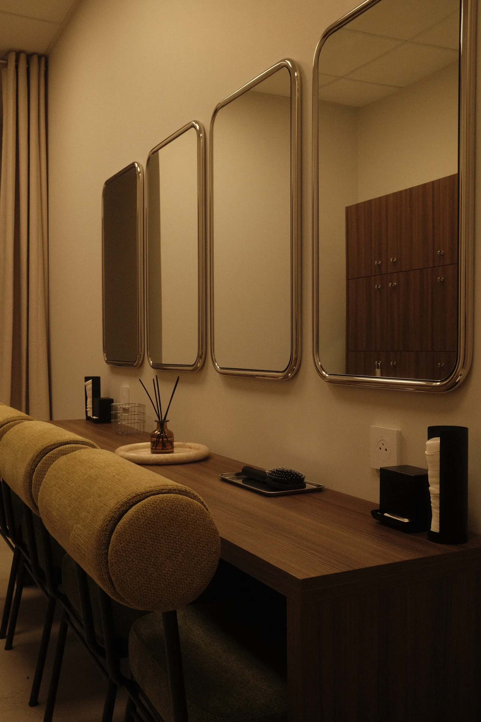 Le vestiaire et sa coiffeuse en noyer, alignée sous quatre miroirs chromés.